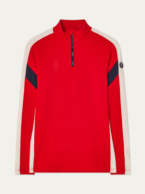 The We Norwegians Zermatt Zipup Men is a red long-sleeve ski sweater with a half-zip front, white sleeve panels, black diagonal arm stripes, and a circular logo patch on the upper left sleeve.