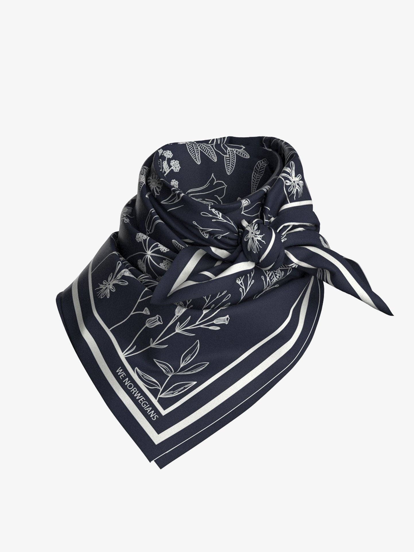 A stylish knot secures the neatly folded Alps Silk Scarf by We Norwegians, made from pure silk in dark blue with white floral patterns and a striped border. This elegant design, featuring various flowers and leaves, is perfect for complementing a chic ski outfit.