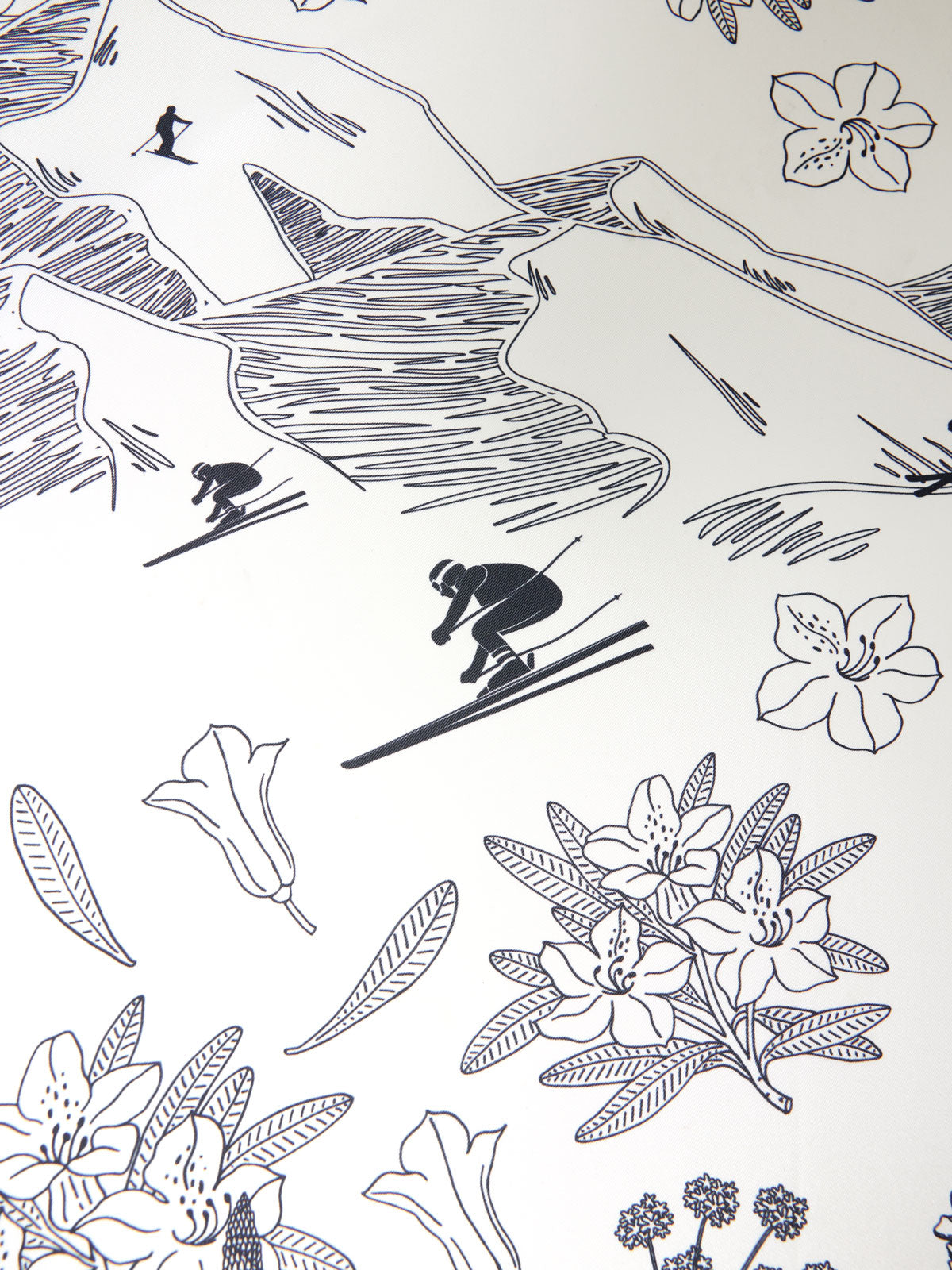 The Alps Silk Scarf by We Norwegians features a simple black and white line drawing that depicts two skiers in the mountains, stylishly dressed in ski outfits, with various flowers such as lilies and other blossoms scattered throughout the image.