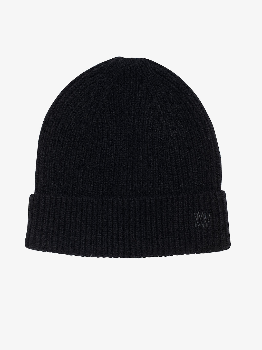 The Blefjell Cashmere Hat by We Norwegians is a black ribbed knit beanie with an adjustable cuff and a simple folded edge, showcasing a minimalist design with tonal embroidery on the edge set against a plain, light gray background.