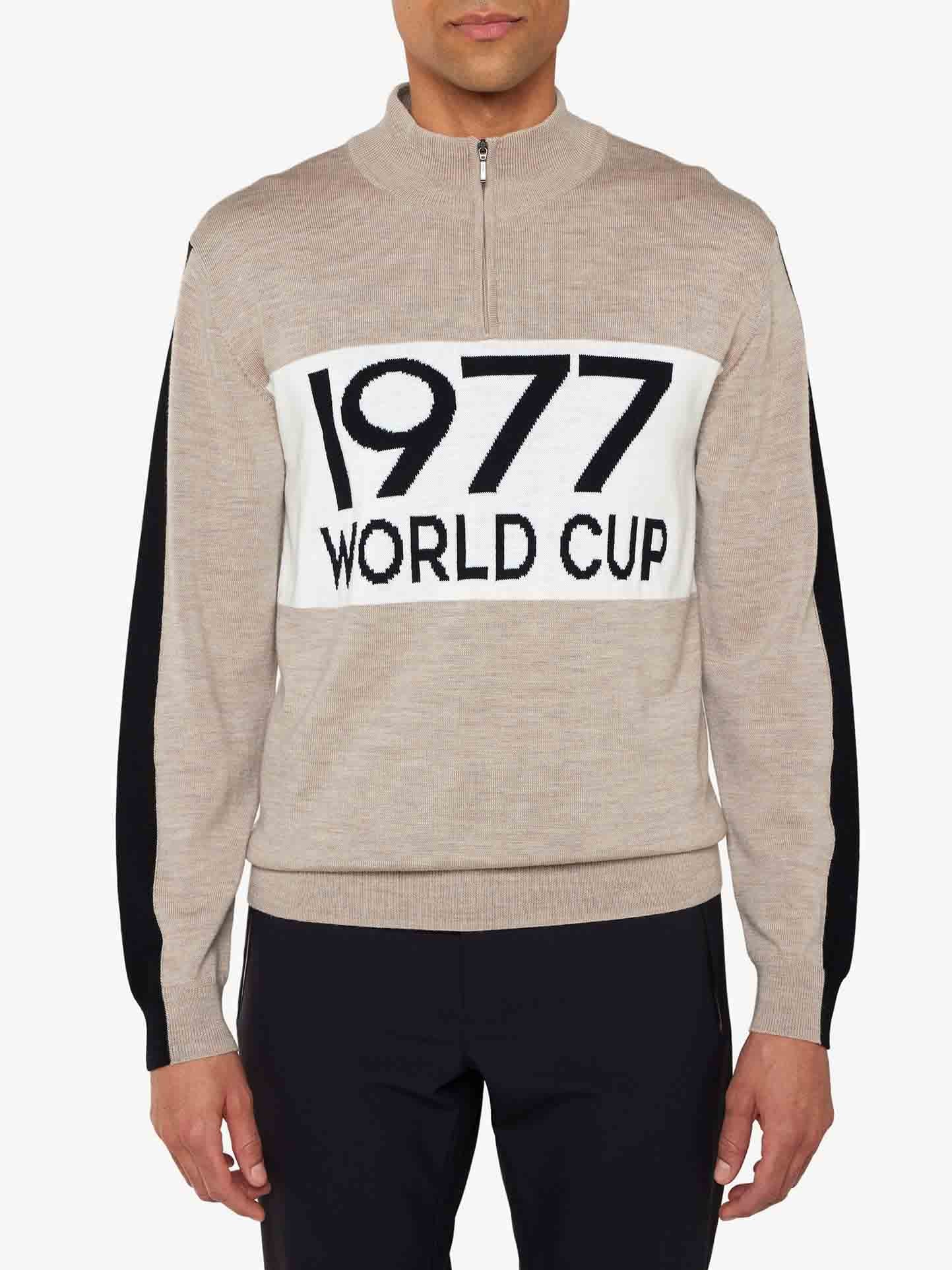 Wearing the We Norwegians 1977 World Cup Zipup Men, one embraces 70s ski fashion. This beige sweater, with black sleeves and a white panel featuring "1977 WORLD CUP" in bold letters, captures Ingemar Stenmark's era. Paired with sleek black pants, the look is timelessly chic.