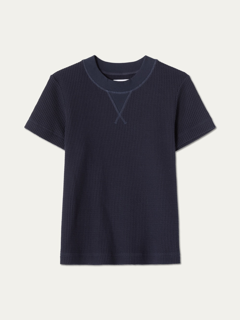 The We Norwegians Waffle Tee Women is a navy short-sleeve 100% cotton tee with a round collar and V-shaped stitch detail, shown on a plain light background.