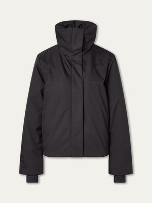 The We Norwegians Western Ski Jacket for women is a black, long-sleeve, high-collar puffer with natural wool padding and a front zipper. It features a clean, minimal design inspired by classic Western ski styles, shown against a plain light background.