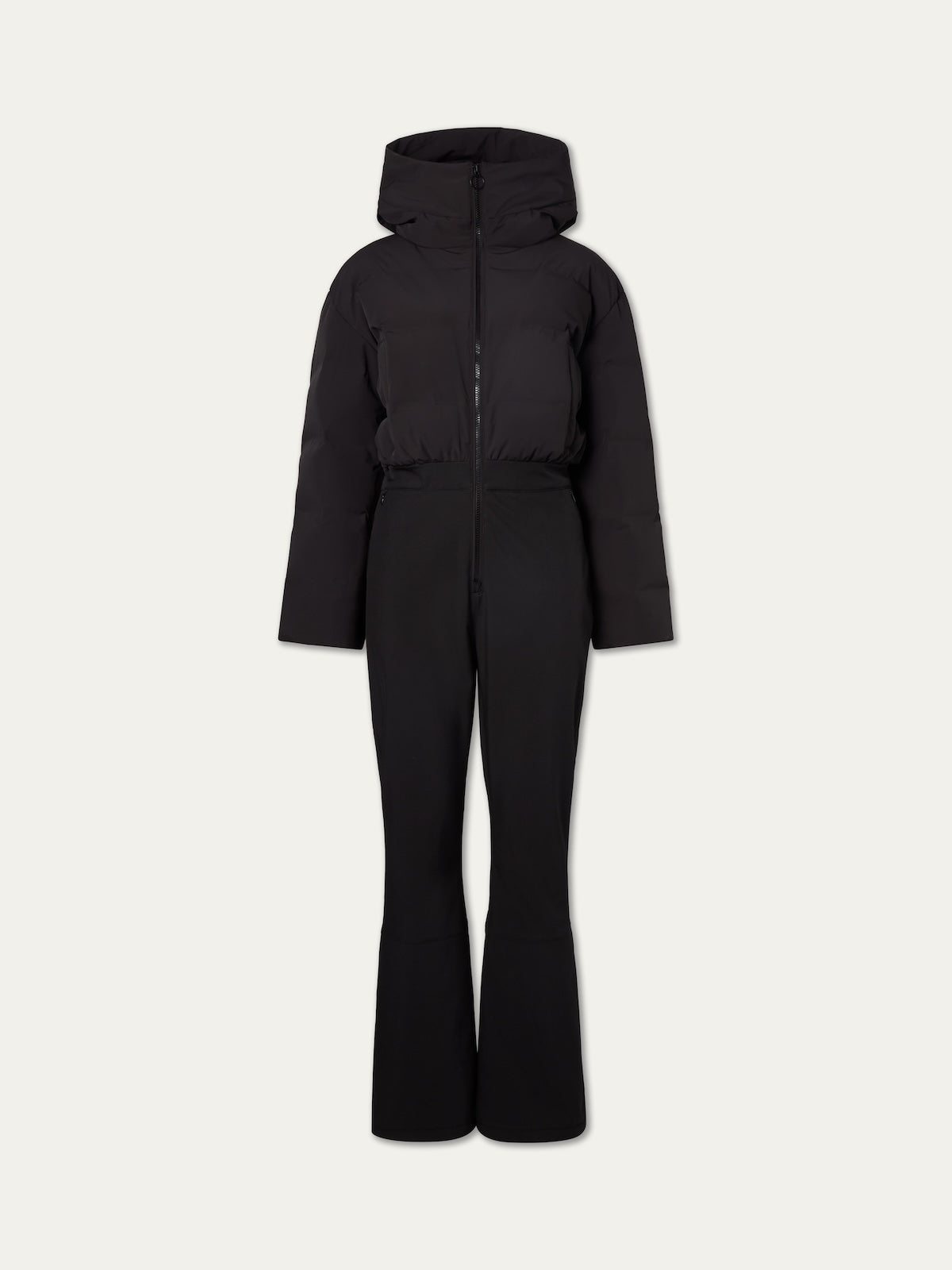The We Norwegians Aurora Ski Suit Women is a black, one-piece ski suit with a fitted waist, flared legs, long sleeves, hood, and front zipper for a sleek alpine look—ideal for stylish days on the slopes.