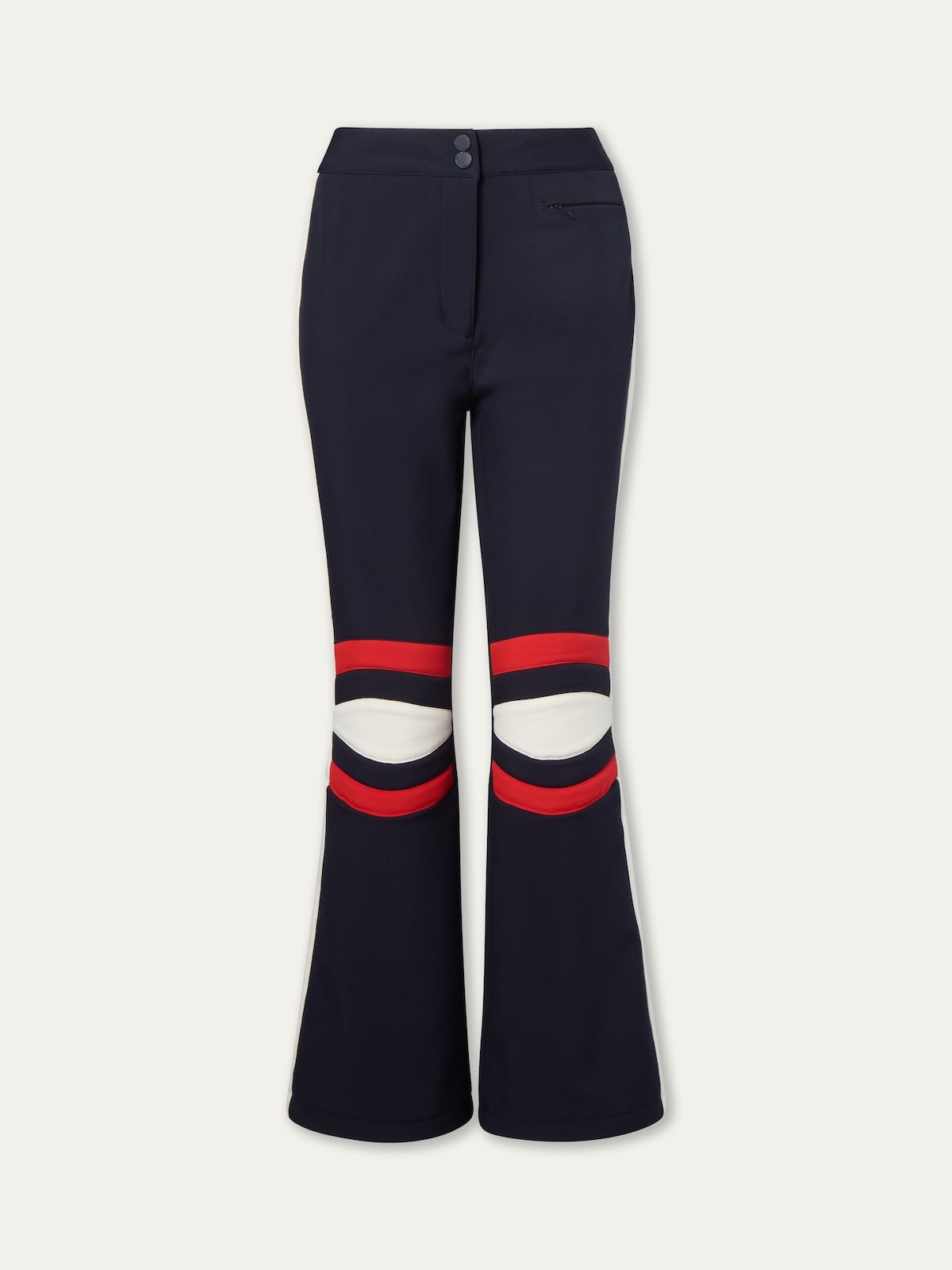 The We Norwegians Solo Ski Pant women features a navy blue flared design with red and white knee stripes, padded knees, front zip and button closure, and a small right-side pocket, offering a modern twist on classic retro ski style.
