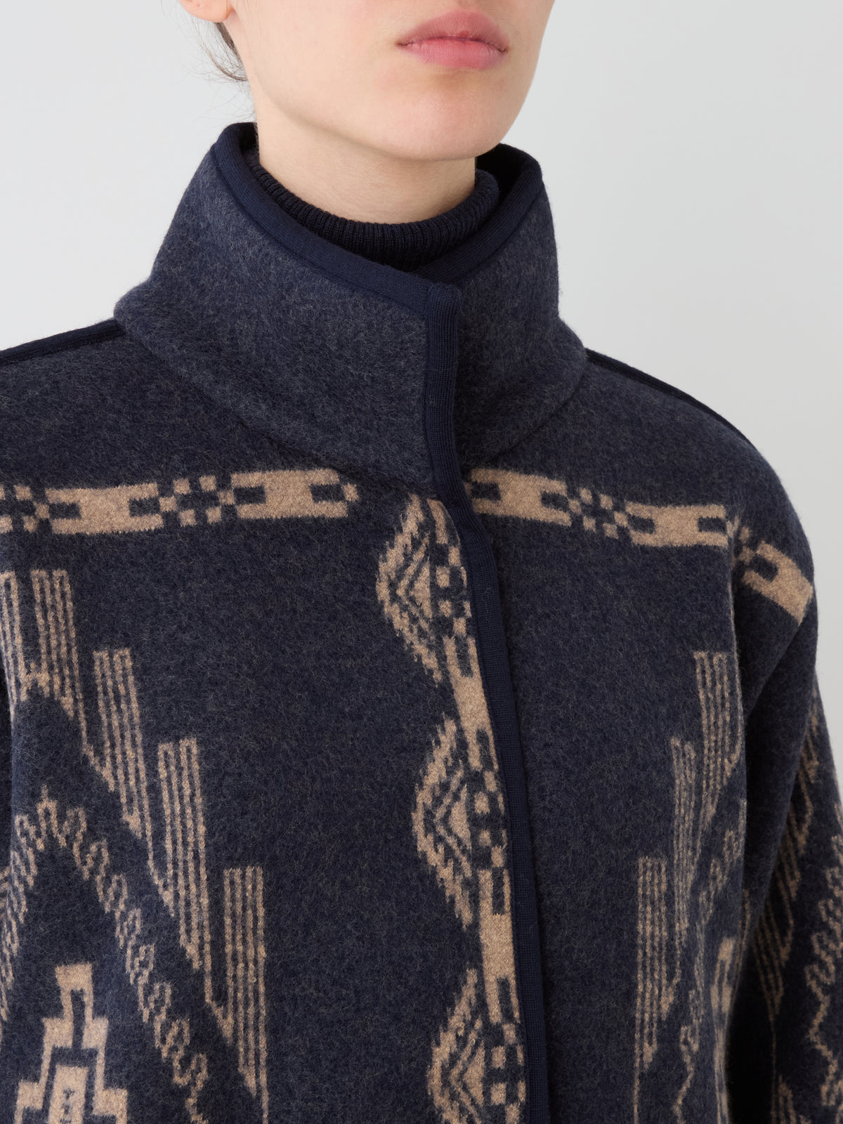 Oversized dark blue boiled wool Pioneer Jacket women with a high collar and tan geometric pattern.