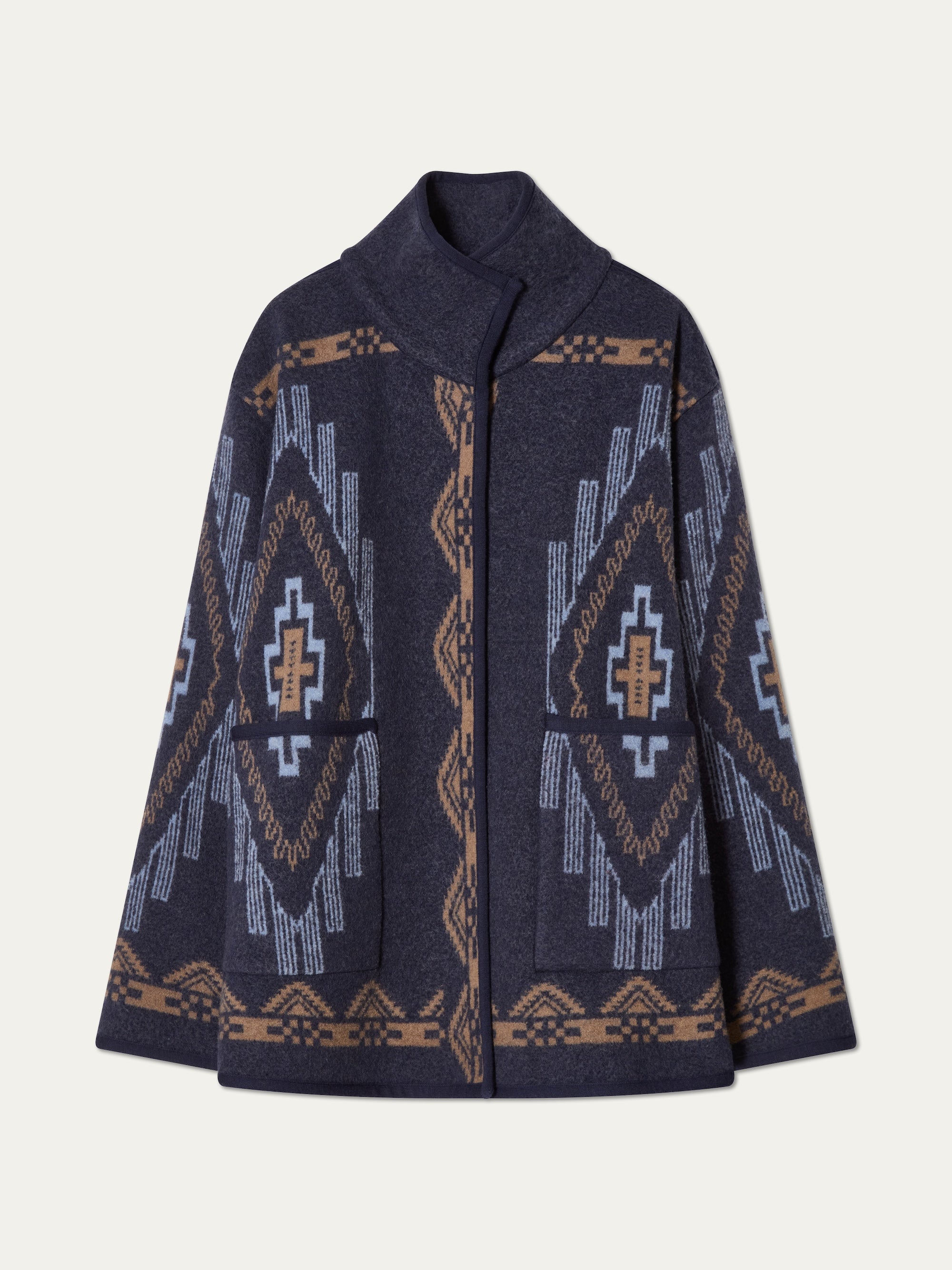 The We Norwegians Kautokeino Jacket for women is a navy boiled wool piece with a high collar and geometric jacquard pattern in light blue, beige, and brown, featuring symmetrical designs on the front, sleeves, and hem.