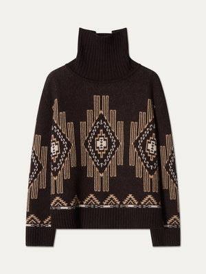 We Norwegians Pioneer Sweater women in a dark brown turtleneck with a tan and white geometric jacquard pattern.