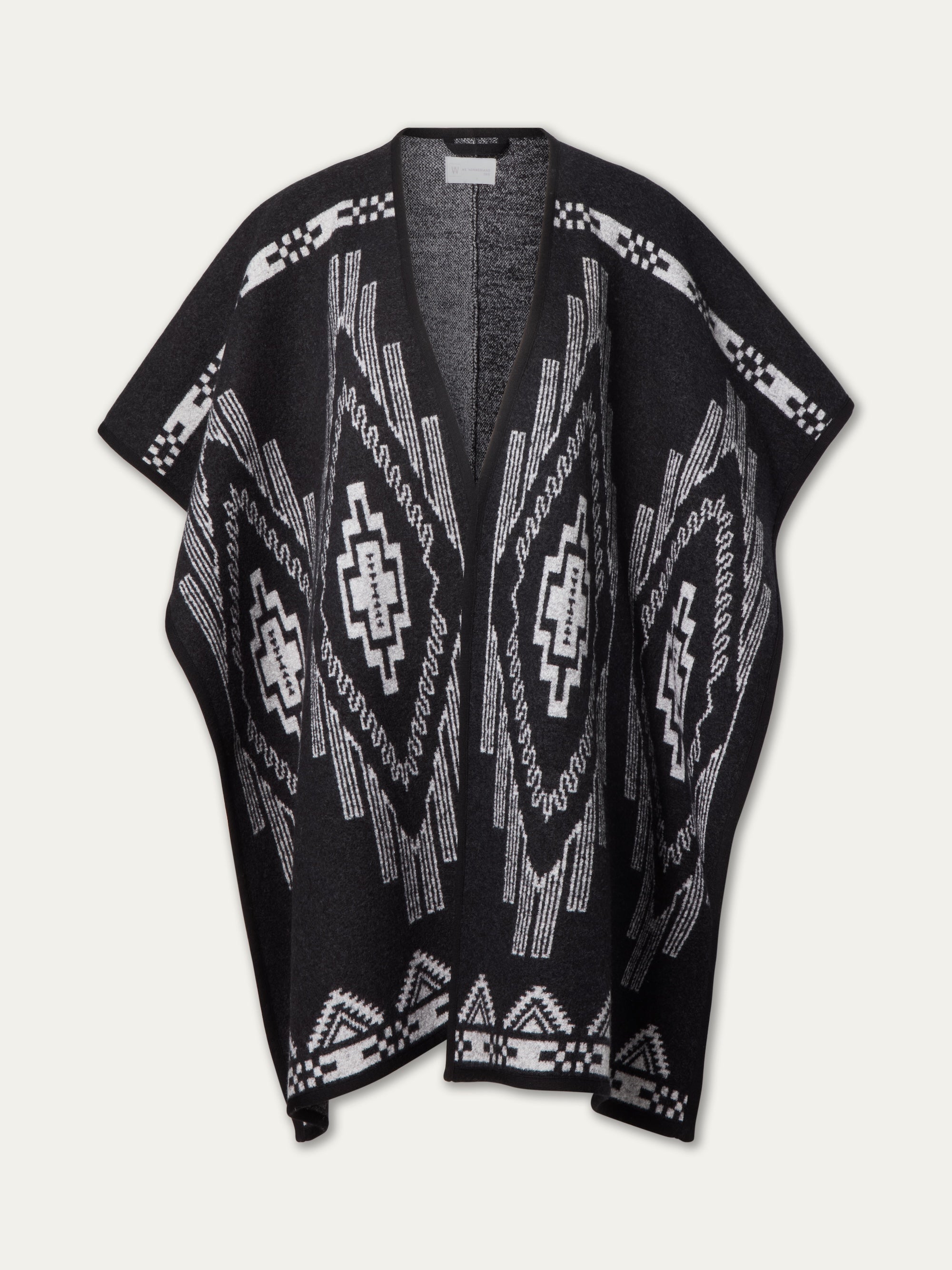 The Kautokeino Poncho Women by We Norwegians impresses with wide sleeves and bold black-and-white geometric and zigzag patterns, making it a standout après-ski piece.