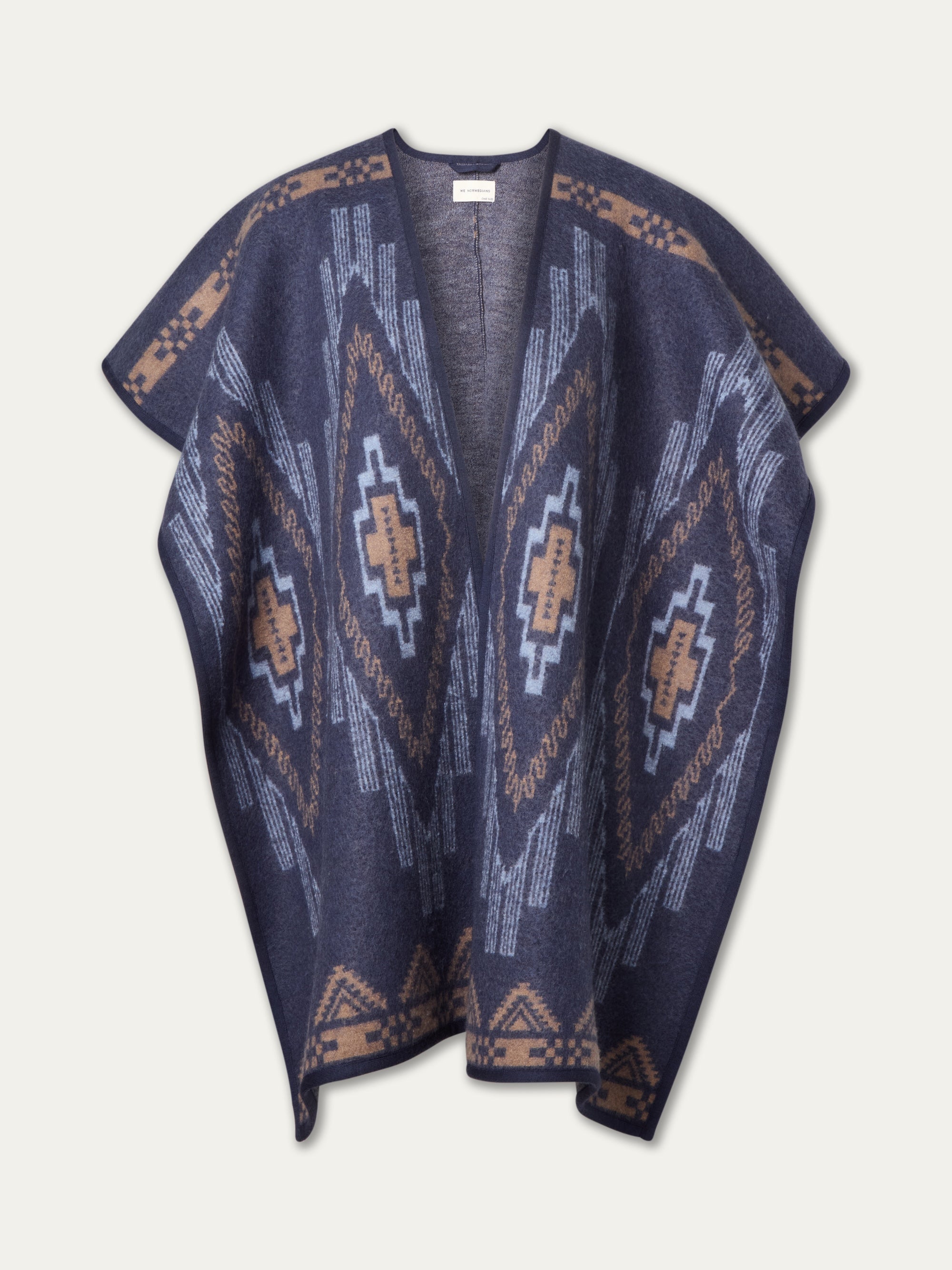 The We Norwegians Kautokeino Poncho women features navy blue boiled wool with tan, beige, and light blue geometric patterns, wide sleeves, and an open front—perfect for your après-ski wardrobe.