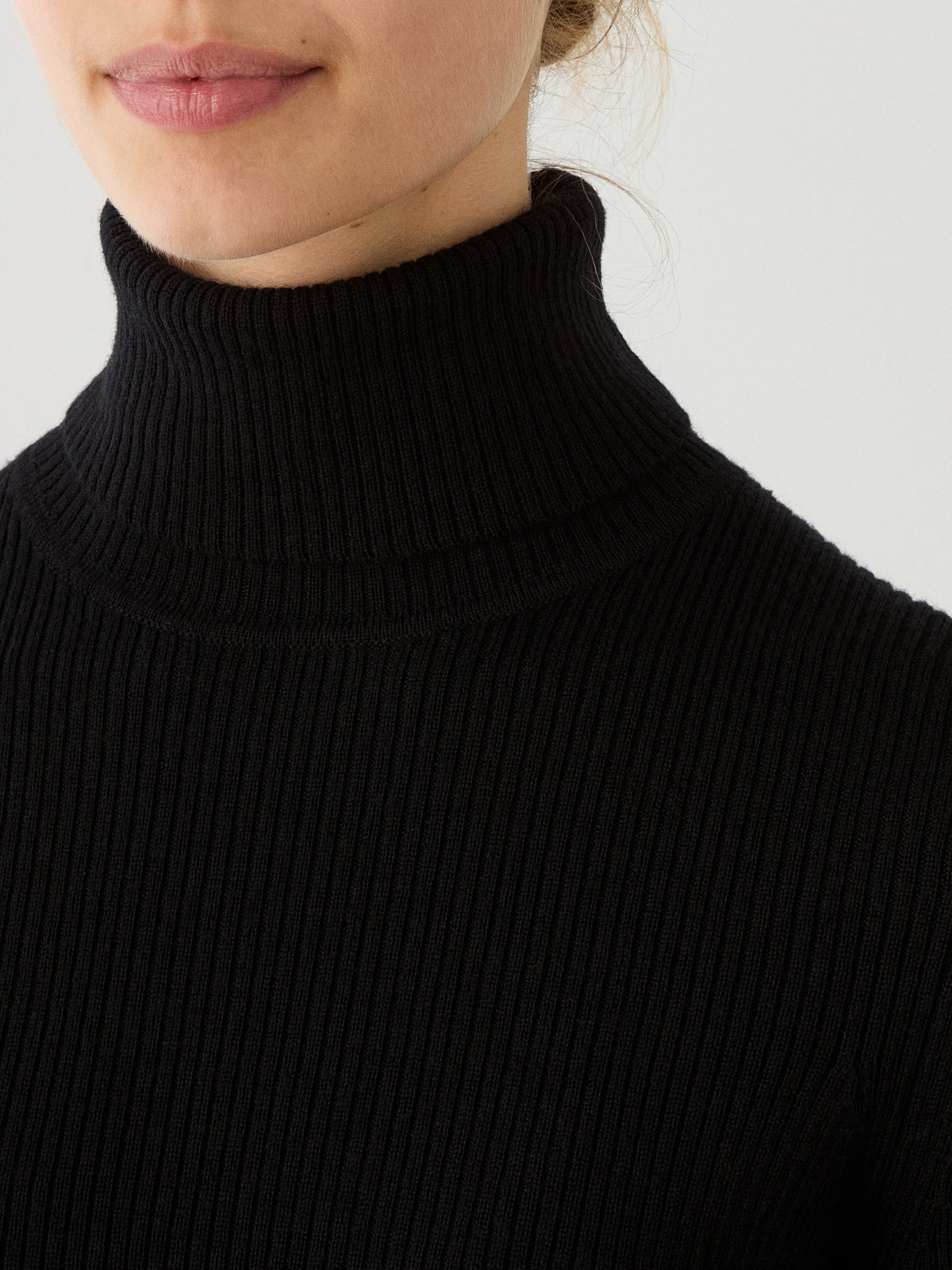 A close-up of a person wearing the We Norwegians Geilo TurtleNeck women sweater, showing the lower half of their face and neck against a plain light background.