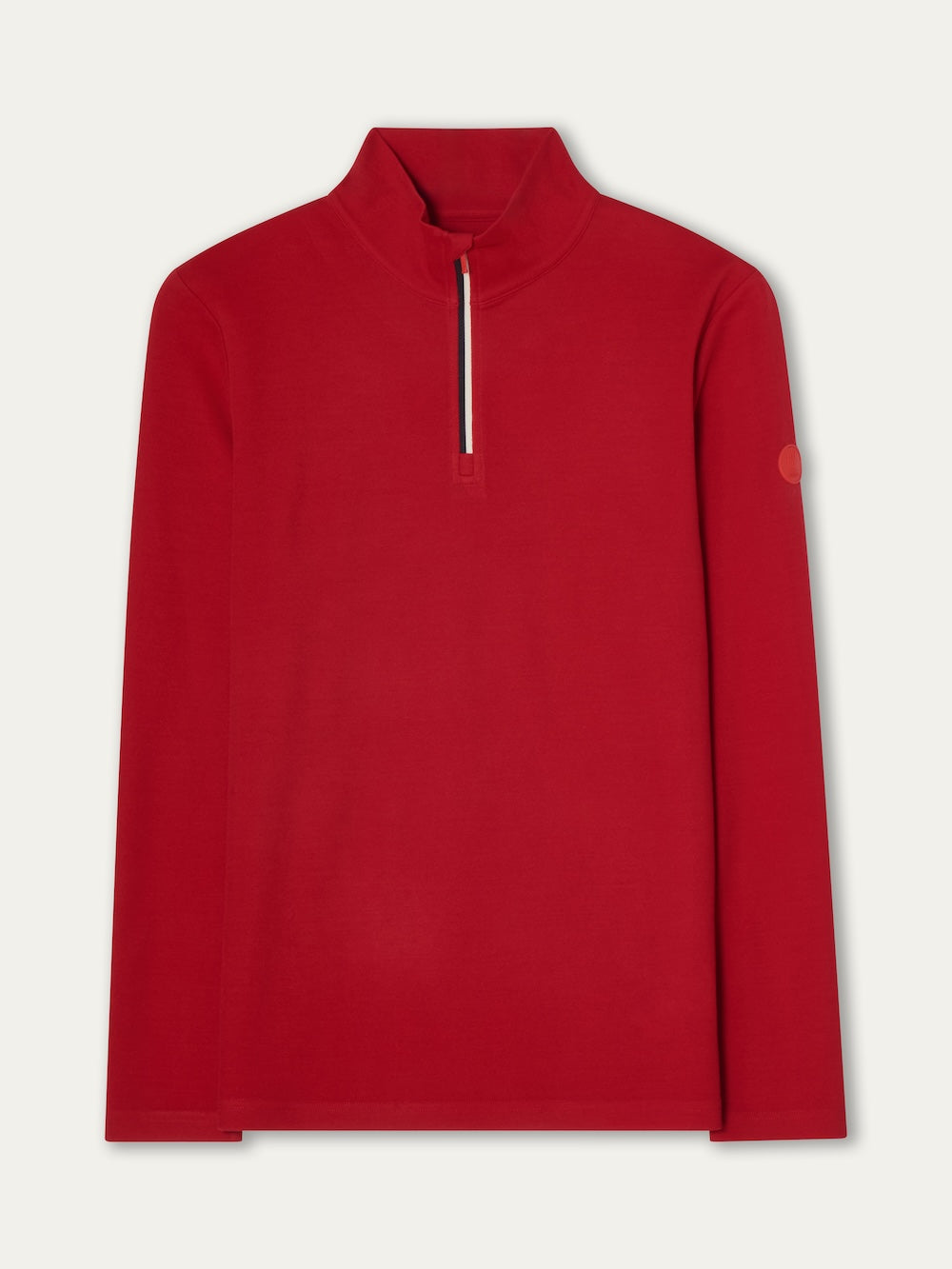 The We Norwegians Moore ZipUp Solid men is a bright red alpine-style long-sleeve pullover with a mock neck, half-zip closure, small zipper pull tab, and a circular patch on the left upper sleeve. It's shown laid flat on a light background.