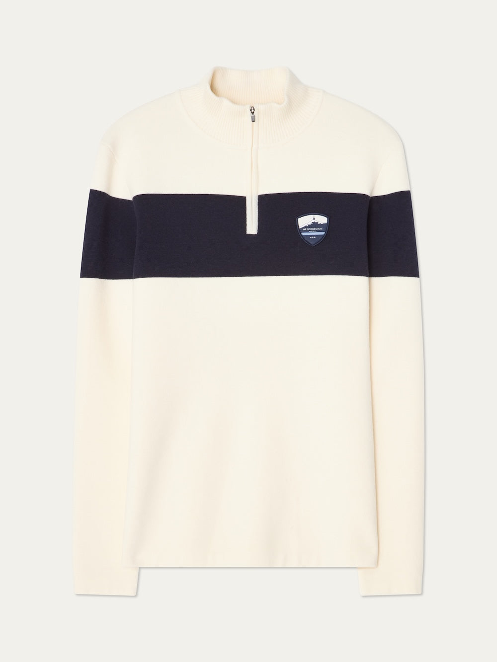 The We Norwegians Holmenkollen ZipUp men’s sweater is cream-colored with a black chest stripe, quarter-zip collar, and a mountain-and-shield logo patch—offering a modern update to the classic vintage ski sweater.