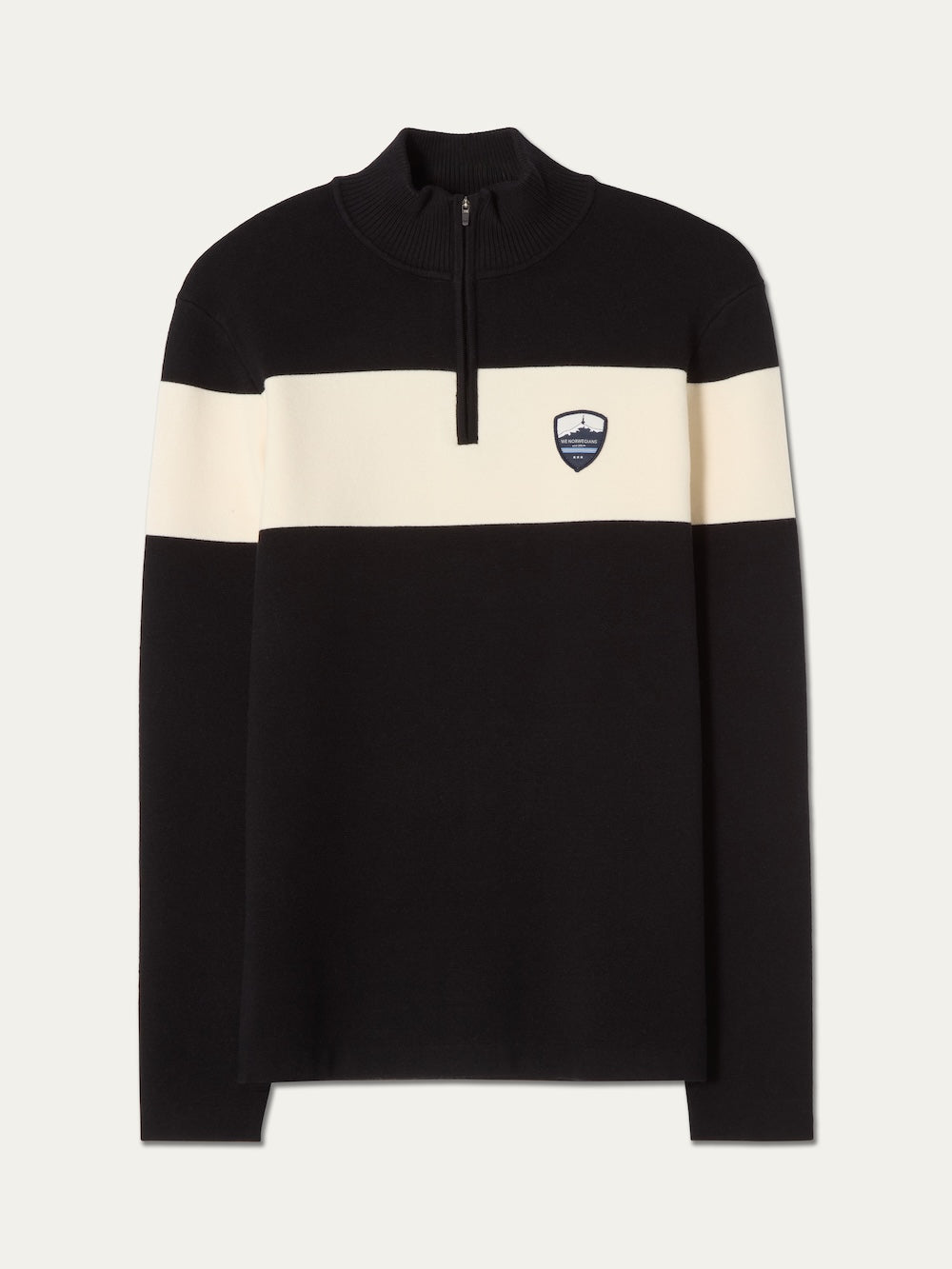The We Norwegians Holmenkollen ZipUp men is a black, long-sleeve sweater featuring a white horizontal stripe across the chest and arms, a short front zipper, and a small crest logo on the left chest—evoking the timeless look of classic vintage ski sweaters.