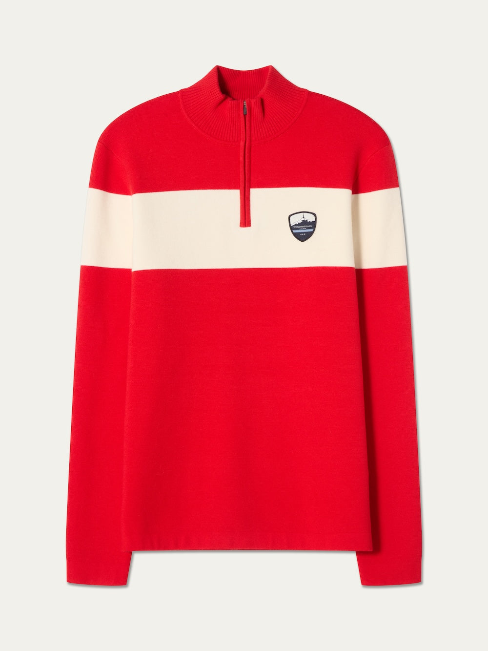 The Holmenkollen ZipUp men by We Norwegians is a red long-sleeve pullover inspired by vintage ski sweaters, featuring a white horizontal stripe across the chest, a short zipper at the neck, and a small black and white patch logo on the left chest.