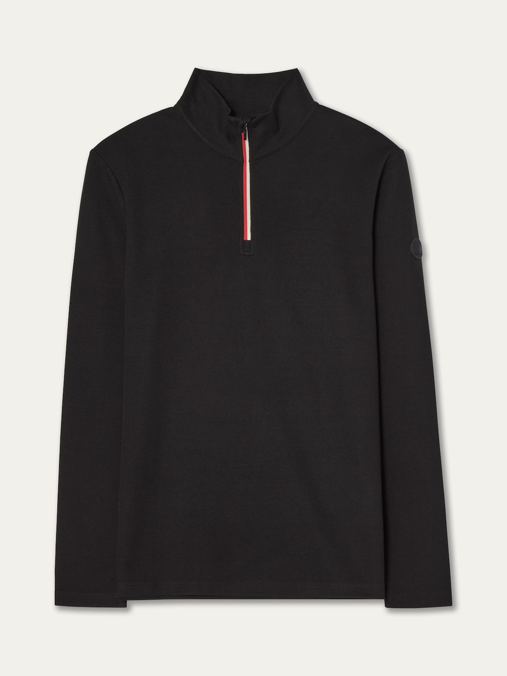 The We Norwegians Bibi ZipUp Solid women’s black long-sleeve pullover features a high collar, front half-zip with red and white stripe detail, minimalist design, and a round sleeve patch—ideal as a ski trip base layer.