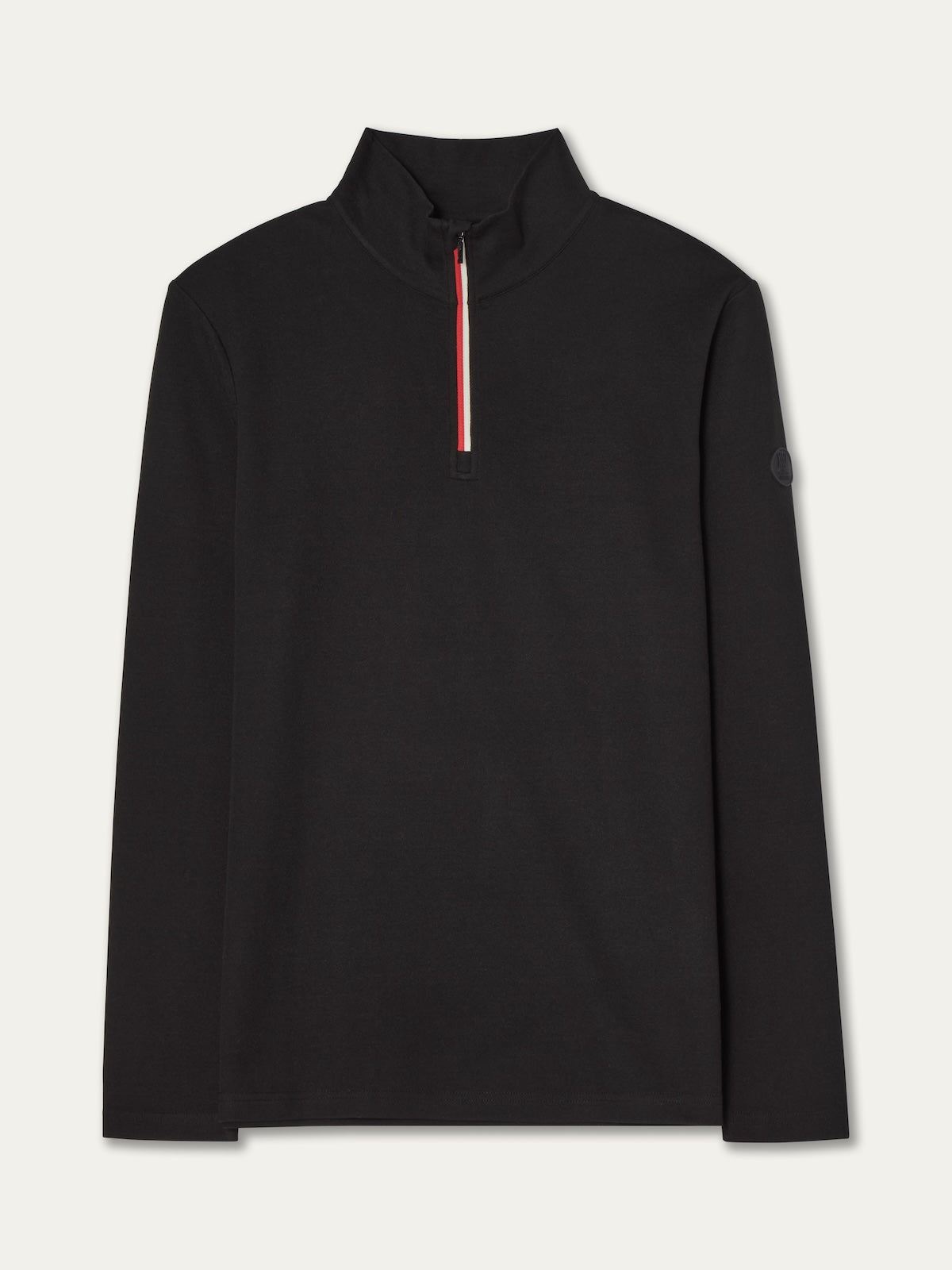 The We Norwegians Bibi ZipUp Solid women’s black long-sleeve pullover features a high collar, front half-zip with red and white stripe detail, minimalist design, and a round sleeve patch—ideal as a ski trip base layer.
