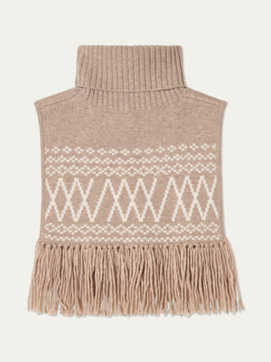 The Setesdal Bib by We Norwegians is a beige Scandinavian-style knit turtleneck dickey with a white geometric pattern and long fringes along the bottom, shown laid flat on a light background.