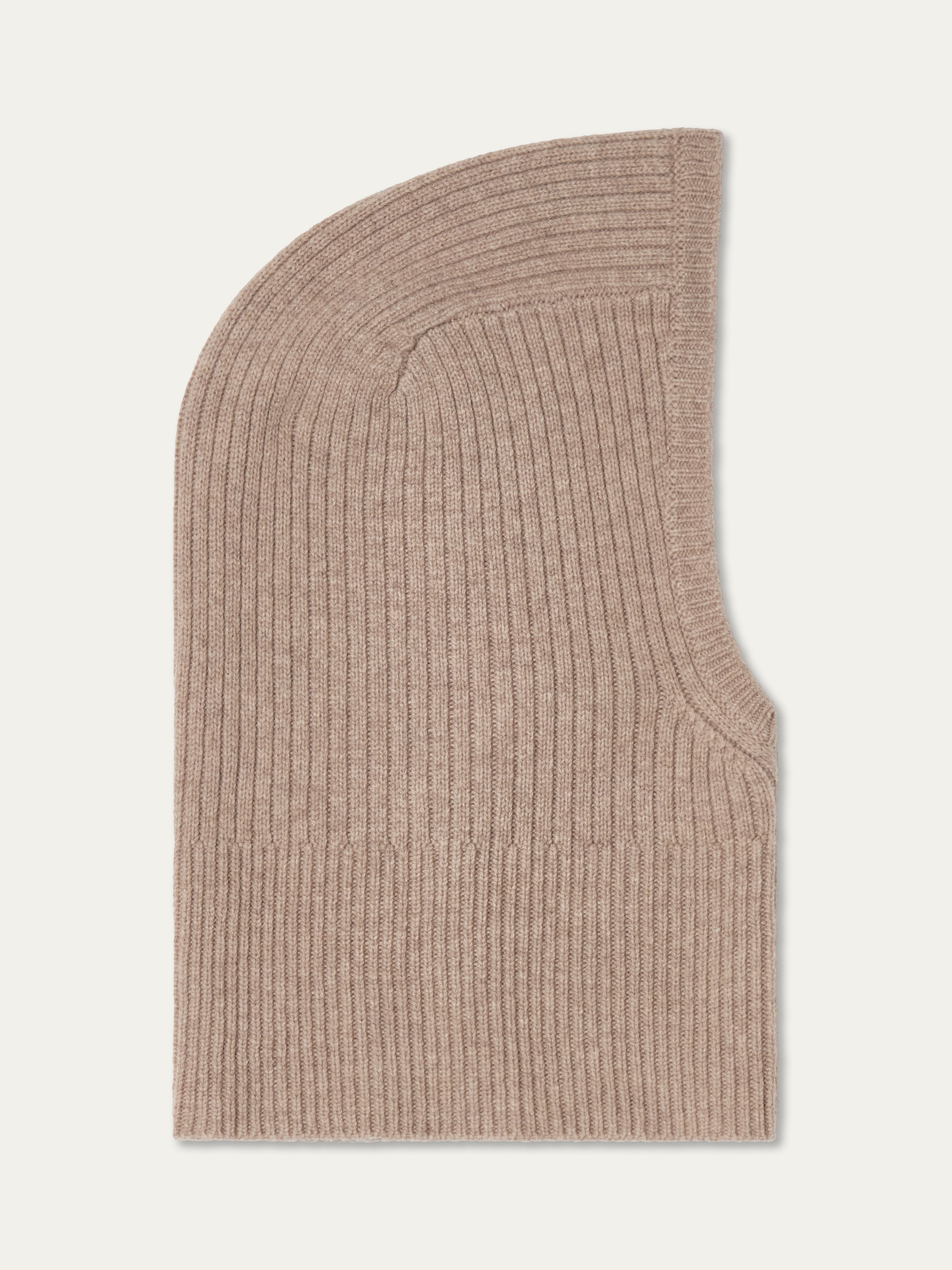 The Dal Balaclava by We Norwegians, in beige ribbed knit cashmere, is shown laid flat with its rounded top and face opening visible—capturing the cozy essence of Scandinavian winter style.