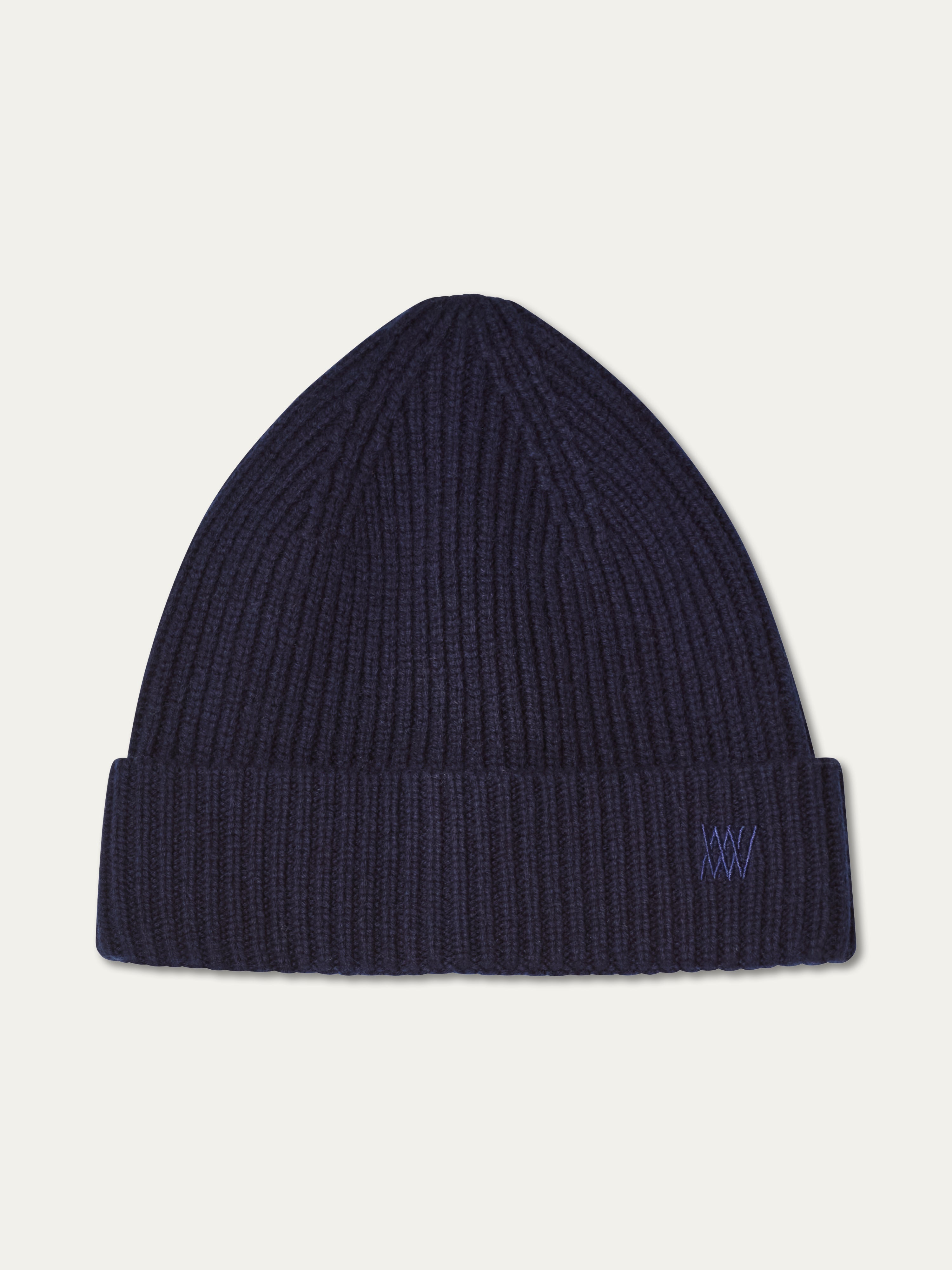 The Dal Hat by We Norwegians is a dark navy Merino wool hat featuring a folded brim and a subtle embroidered logo on the cuff, shown against a plain white background.