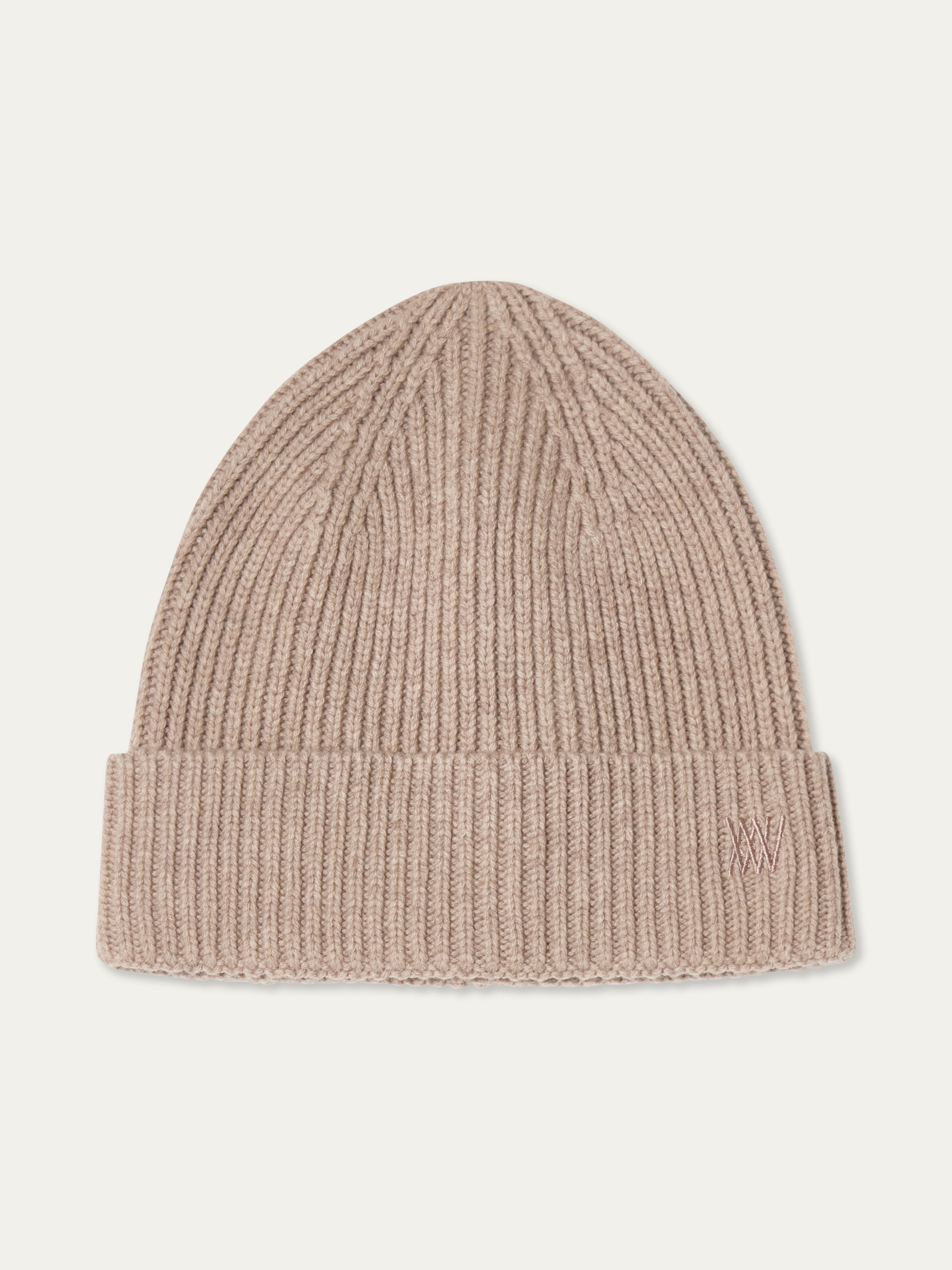 The Dal Hat by We Norwegians is a beige, ribbed knit Scandinavian-style beanie with a folded cuff and subtle "AW" embroidery, shown laid flat on a plain, light background.