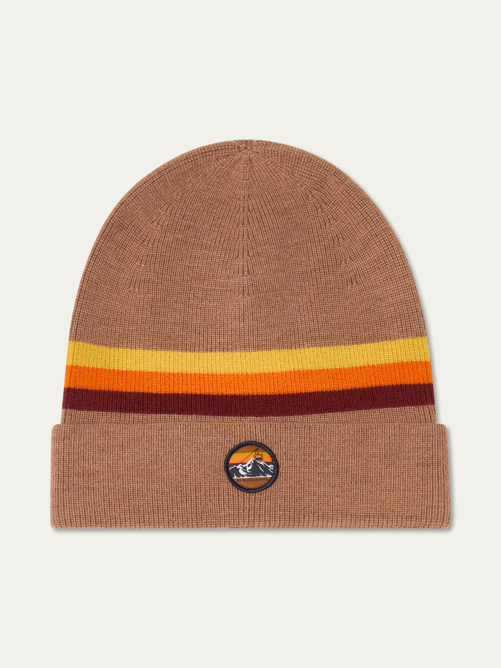 A brown knit We Norwegians FreeBird Hat features horizontal yellow and orange rainbow stripes near the top and a mountain patch on the cuff, shown on a light background.