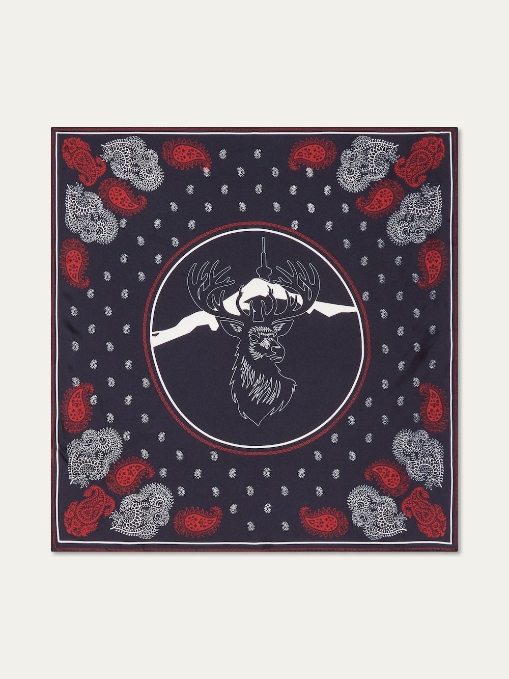 The We Norwegians Western Silk Scarf is a navy blue accessory inspired by Norwegian heritage, with a white outlined deer head center, mountain silhouettes, red and white paisley corners, and scattered small white dots.