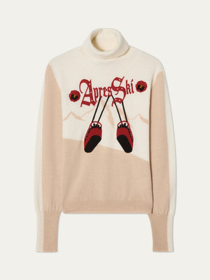 The WN x Markarian Aprés Ski Sweater by We Norwegians is a cream and beige limited edition women's knit with long sleeves, featuring "Apres Ski," mountain outlines, red flowers, and crossed red skis with black tips.