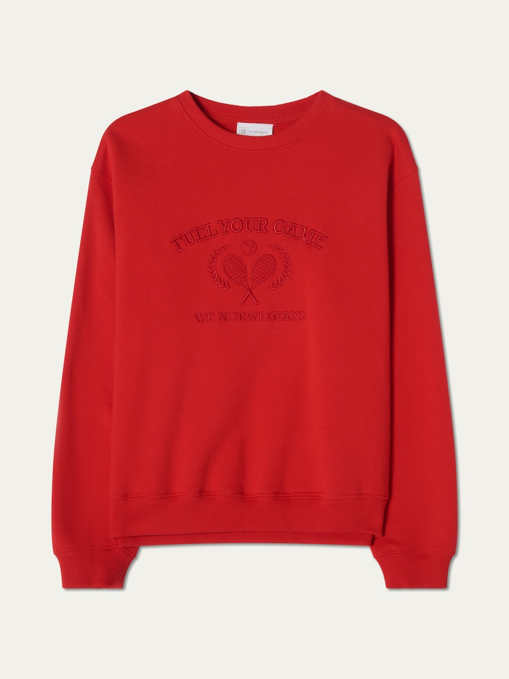 The We Norwegians Bounce Sweater Women is a plain red crew neck with ribbed cuffs and hem, featuring tennis embroidery of two crossed rackets, laurel wreaths, and the words "FULL YOUR GAME" and "WE NORWAY CLUB" on the front.