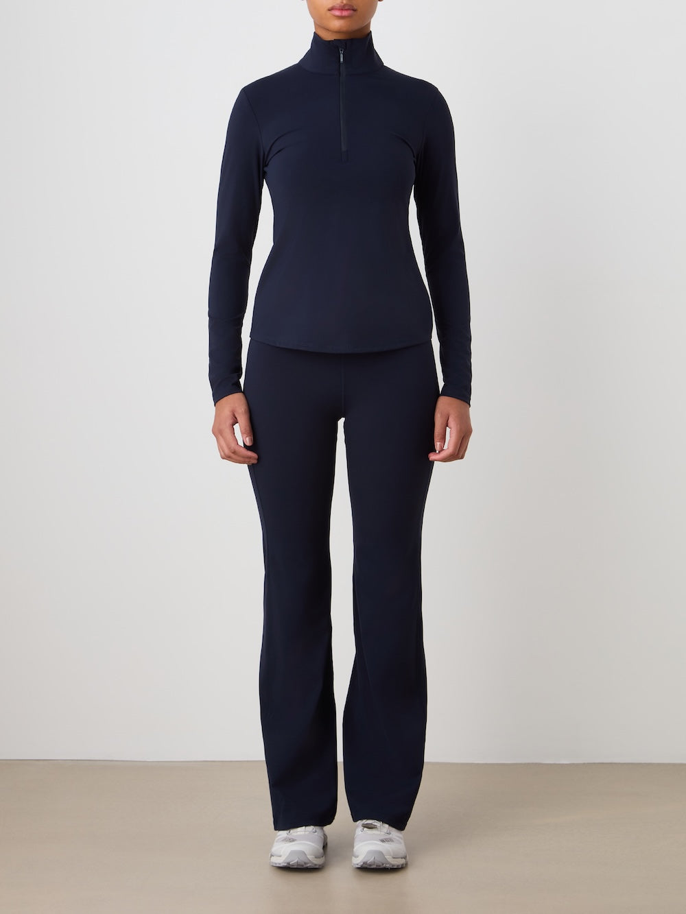 Person wearing a navy long-sleeve top and pants on a plain background