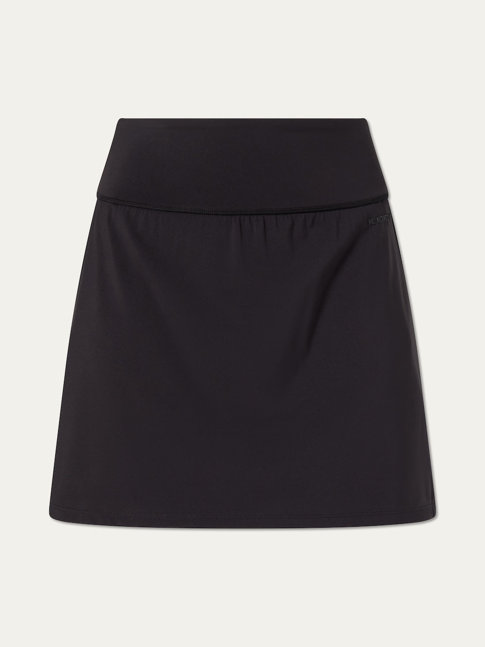 The We Norwegians Honor Skirt Women is a plain black A-line performance skirt with built-in shorts, a wide waistband, and smooth fabric, shown against a white background.