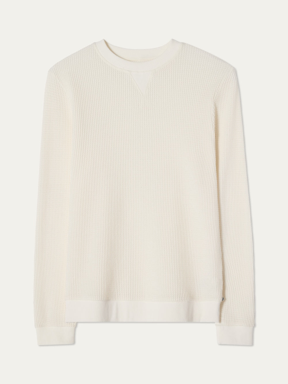 The We Norwegians Waffle Crewneck Men is an off-white, long-sleeve cotton sweater with ribbed cuffs and hem, relaxed fit, and a classic waffle texture, shown laid flat on a neutral background.