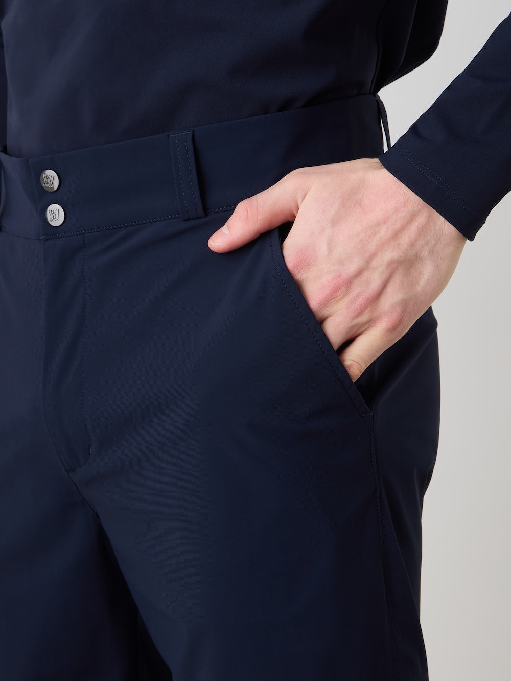 A person wears We Norwegians Albatross Shorts Men, showcasing the quick-drying, breathable stretch waistband with two metallic buttons as they place their right hand in the pocket.