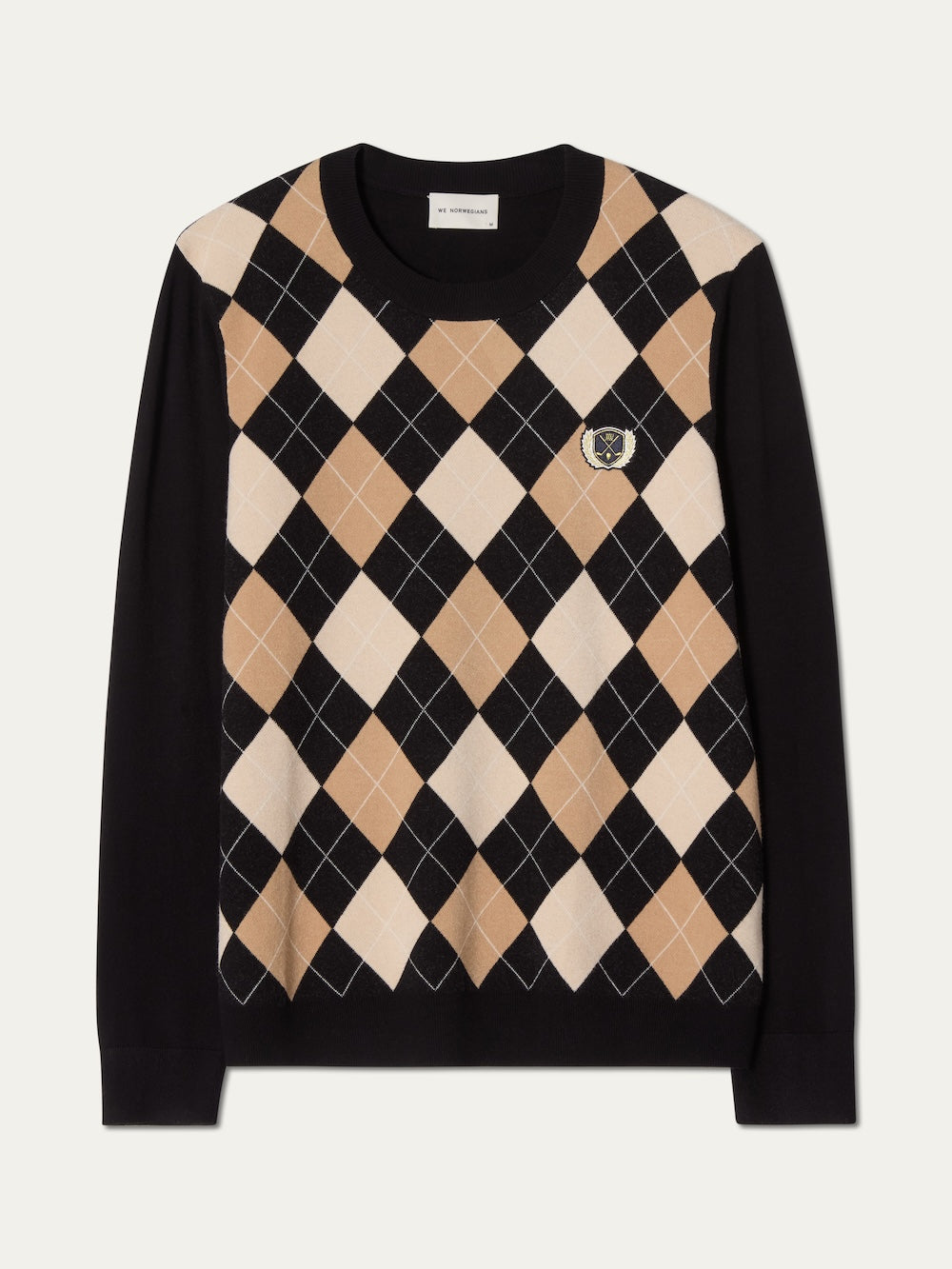 The Fairway Sweater Men by We Norwegians is a black, long-sleeve golf sweater with a beige, white, and black argyle knit front, small chest crest, and solid black sleeves and back for classic style and breathable comfort.