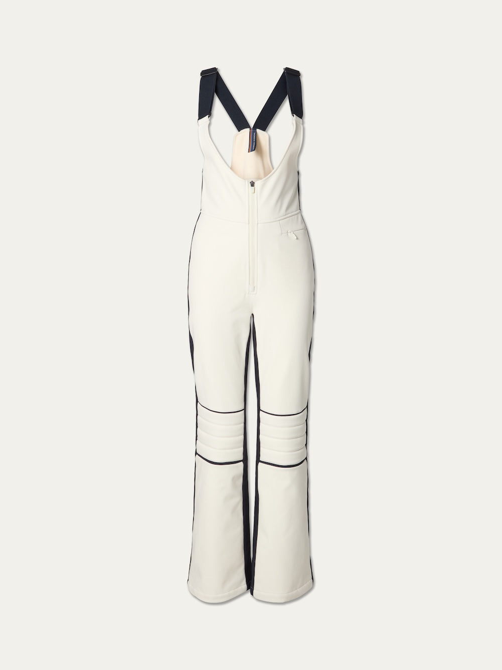 The Solo Bib Pant Women by We Norwegians features wide black suspenders, a front zipper, black side piping, and padded knee panels for a vintage alpine ski look on a plain light background.