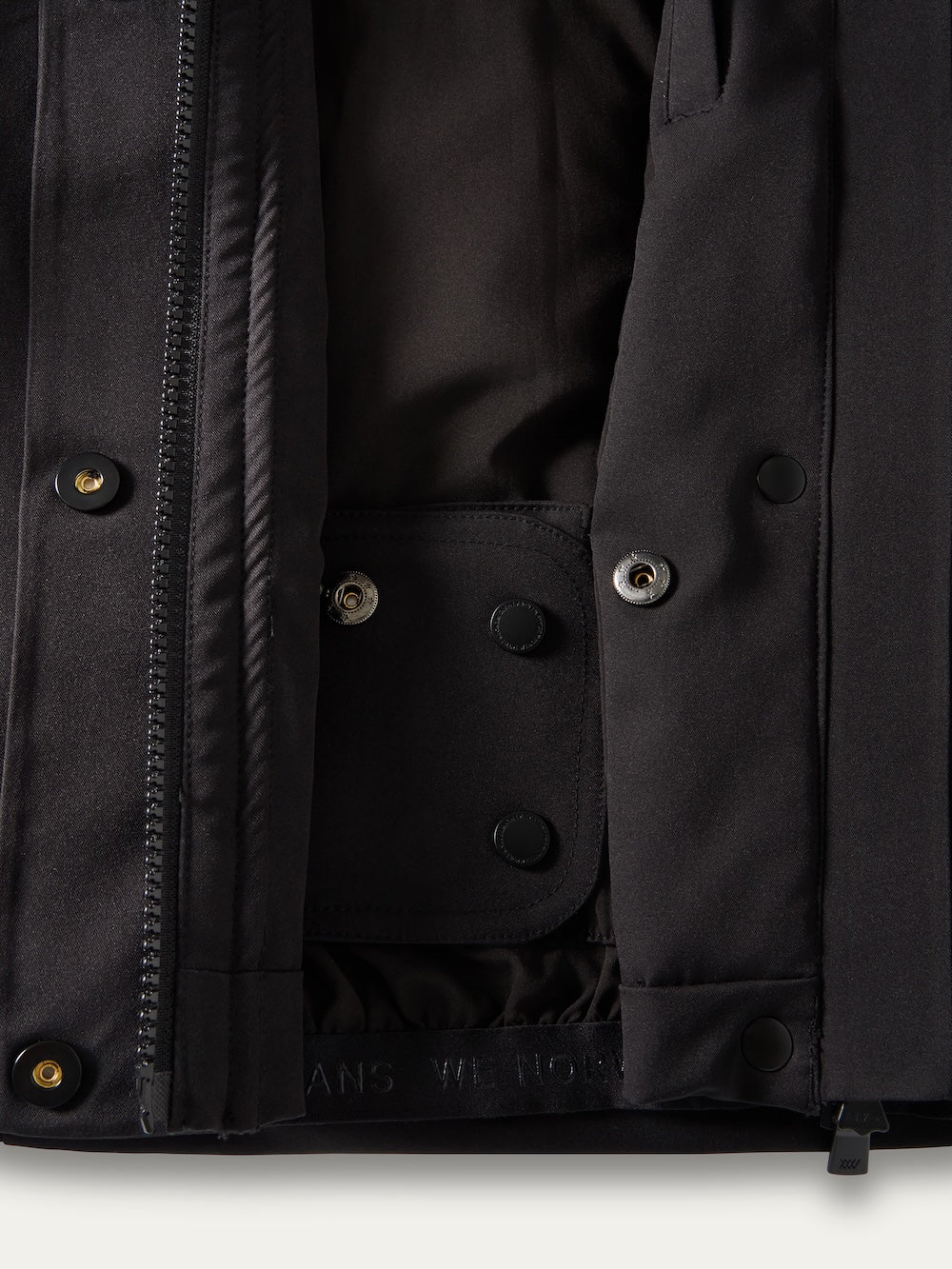Close-up of a black We Norwegians Finse Ski Jacket Women showing metal snaps, zippers, and inner lining, highlighting the modern ski jacket’s construction and details.