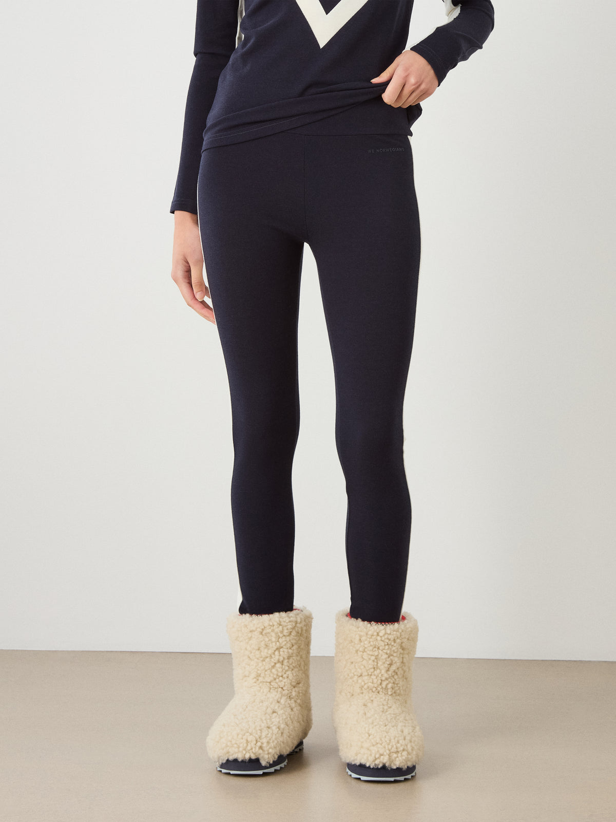A person wearing dark navy Voss Leggings Women and cream-colored fleece-lined boots.