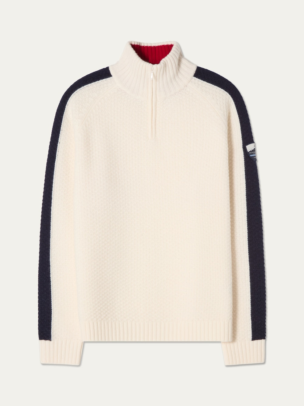 The We Norwegians Kikut ZipUp Sweater Men is a cream-colored sweater made from soft merino wool, featuring a half-zip collar, black stripes down the sleeves, ribbed cuffs and hem, and a small patch on the upper left sleeve—ideal for après-ski comfort on cozy mountain evenings.