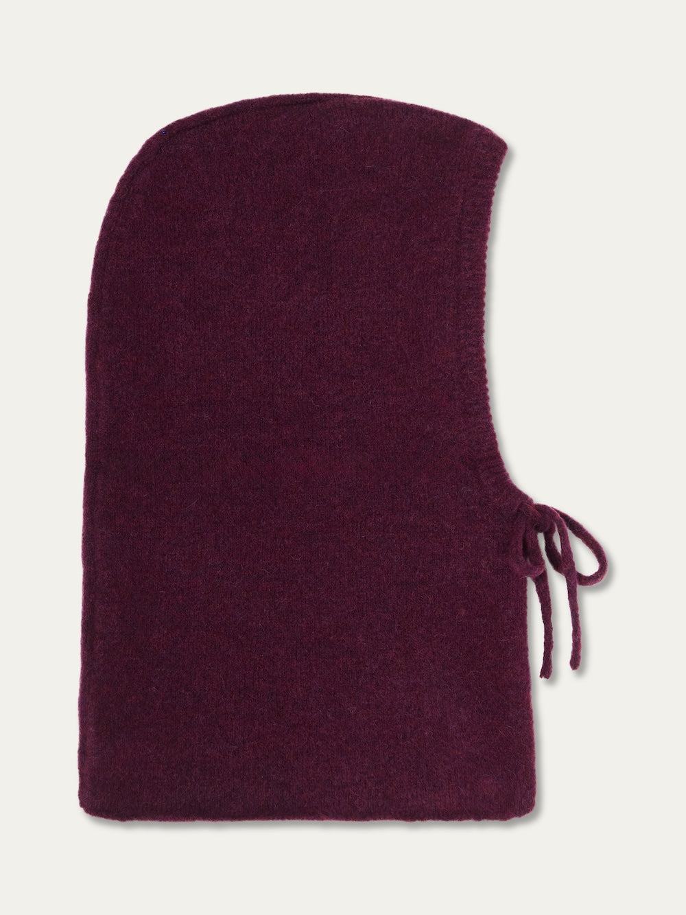 The Norefjell Hood by We Norwegians is a cosy burgundy knit balaclava with a rounded top, open face, and side tie detail—an ideal winter accessory, shown laid flat on a plain background.