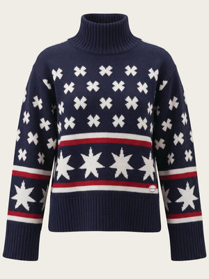 The EMU x WN Sweater Women by We Norwegians is a navy blue turtleneck ski sweater adorned with white star and cross patterns, red and white stripes, and features ribbed cuffs and hem—perfect for an après-ski look or staying cozy in a classic merino wool style.