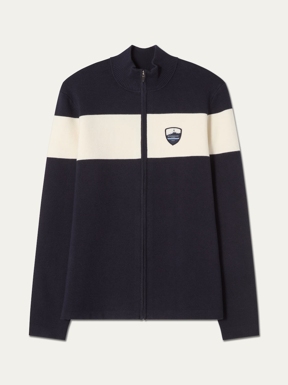 The We Norwegians Holmenkollen Full Zip Men jacket in navy blue features a white horizontal stripe across the chest and arms, accented with a small shield emblem on the left chest. Inspired by Scandinavian mountain heritage, this piece seamlessly combines timeless style with functional design.
