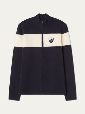 The We Norwegians Holmenkollen Full Zip Men jacket in navy blue features a white horizontal stripe across the chest and arms, accented with a small shield emblem on the left chest. Inspired by Scandinavian mountain heritage, this piece seamlessly combines timeless style with functional design.