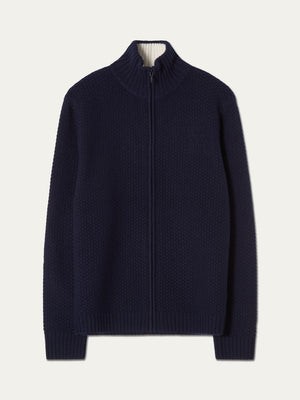 The We Norwegians Kikut FullZip Men is a navy blue, full-zip cardigan featuring a high collar, ribbed cuffs and hem, crafted in a classic alpine sweater style and laid flat on a plain white background.