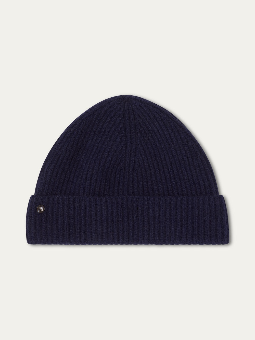 The Blefjell Hat For All by We Norwegians is a navy blue ribbed knit beanie in pure cashmere, featuring a folded brim and small metallic tag. This classic, one-size-fits-most accessory is shown against a plain white background.
