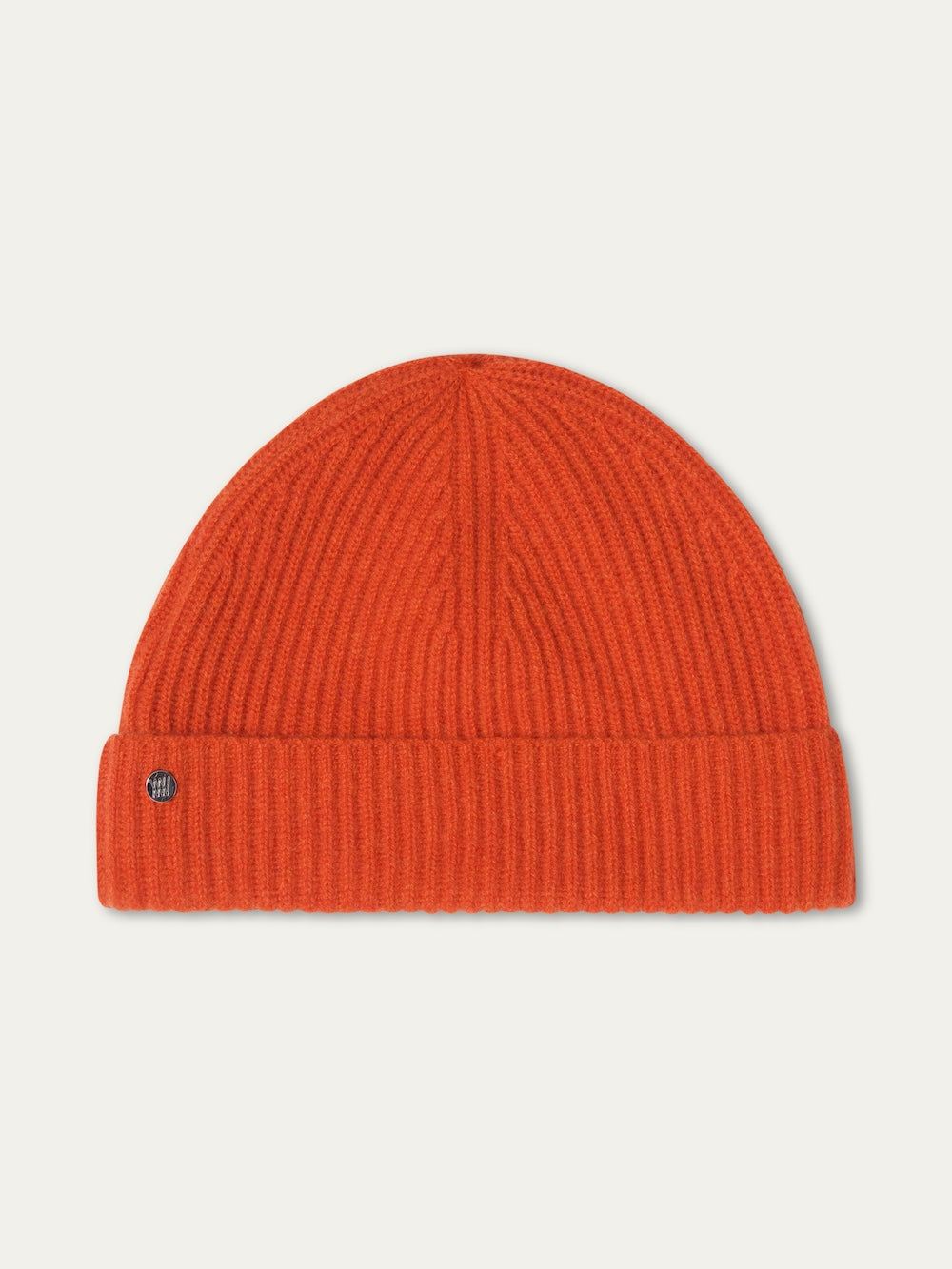 The Blefjell Hat For All by We Norwegians is a bright orange pure cashmere ribbed hat with a folded brim and round metal emblem on the left, shown against a white background—a classic one size accessory.