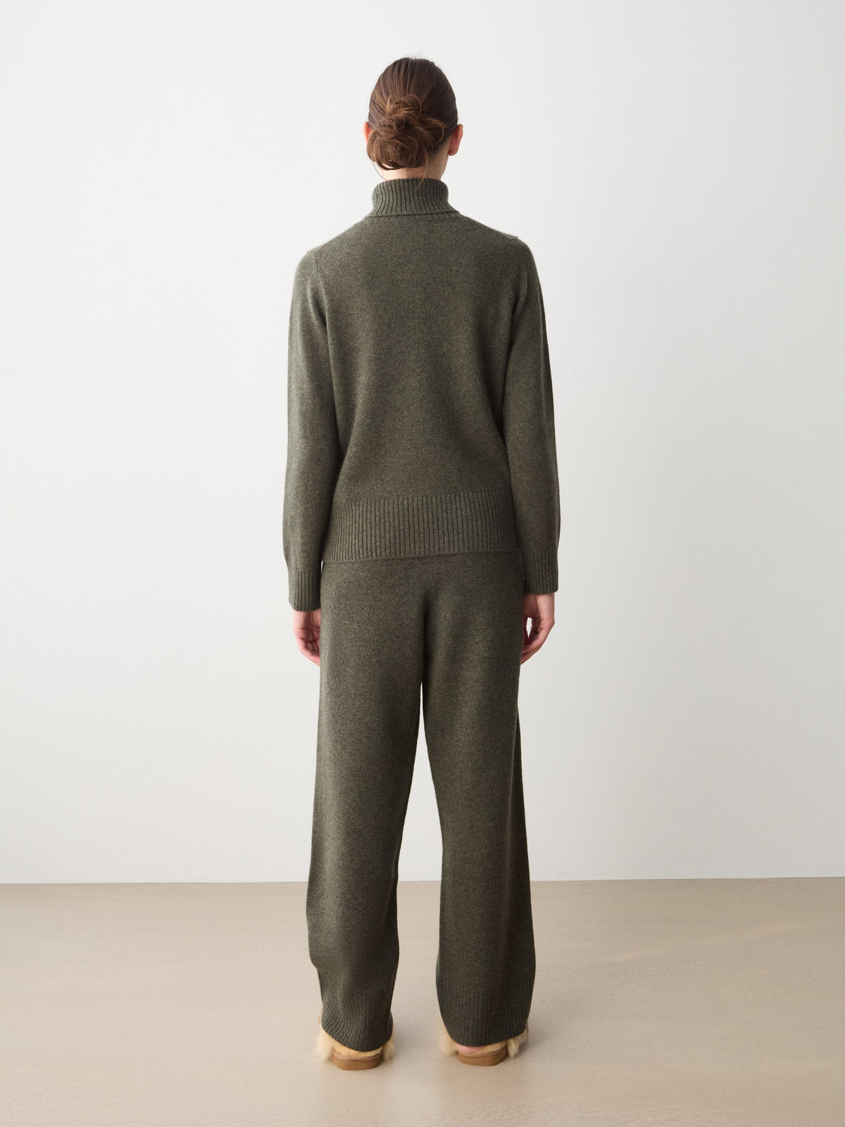 A woman seen from behind wearing a Monogram Cashmere Sweater and matching wide-leg lounge pants by We Norwegians.