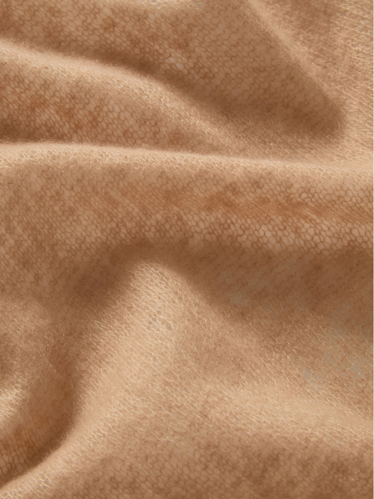 Close-up of a featherlight, tan We Norwegians Monogram Cashmere Scarf featuring a delicate, repeating knitted pattern.