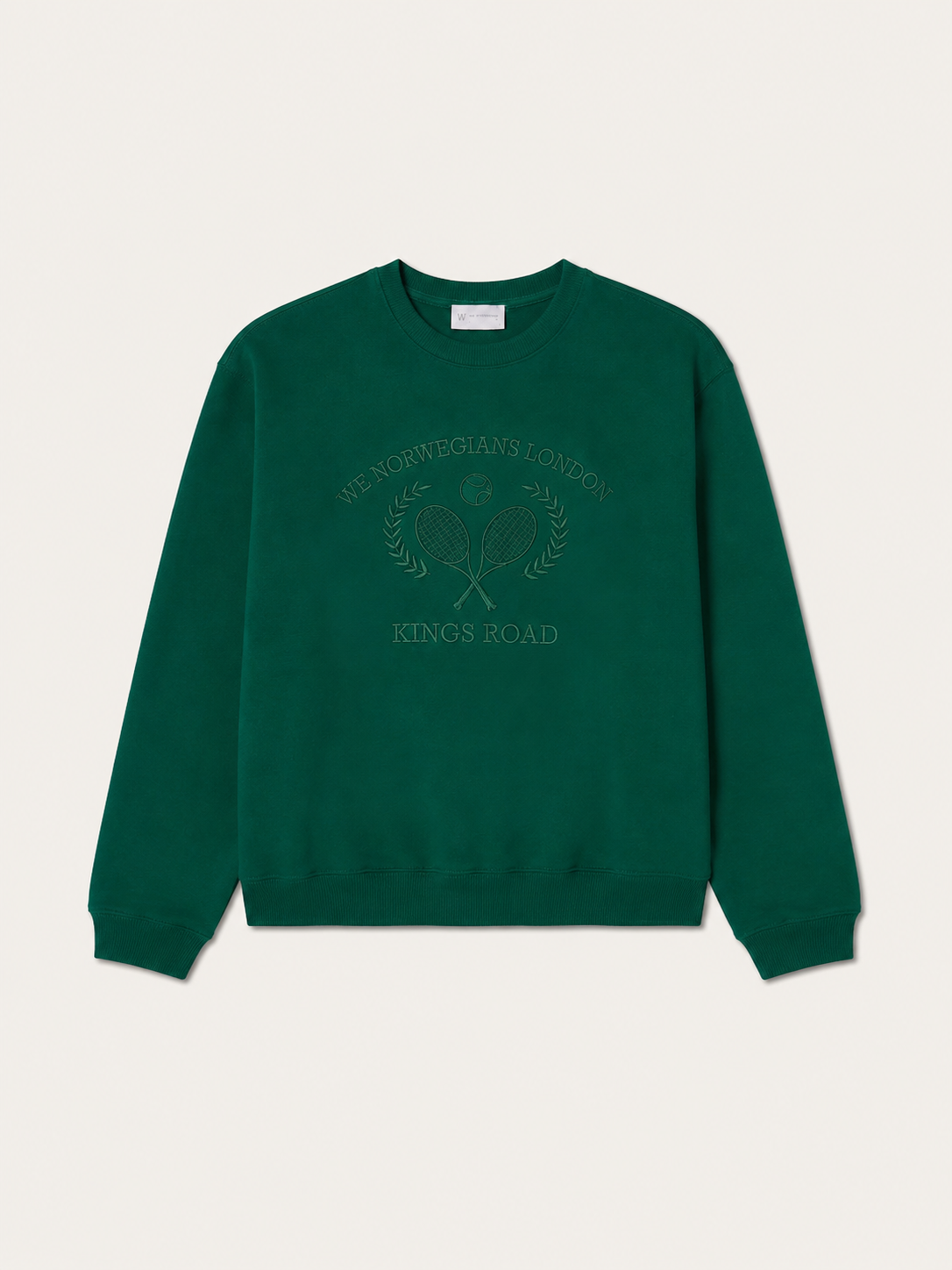 The Chelsea Sweater Women by We Norwegians is a green cotton jersey crew neck with an embossed front: two crossed tennis rackets, laurel branches, and “We Norwegians London Kings Road” embroidery.