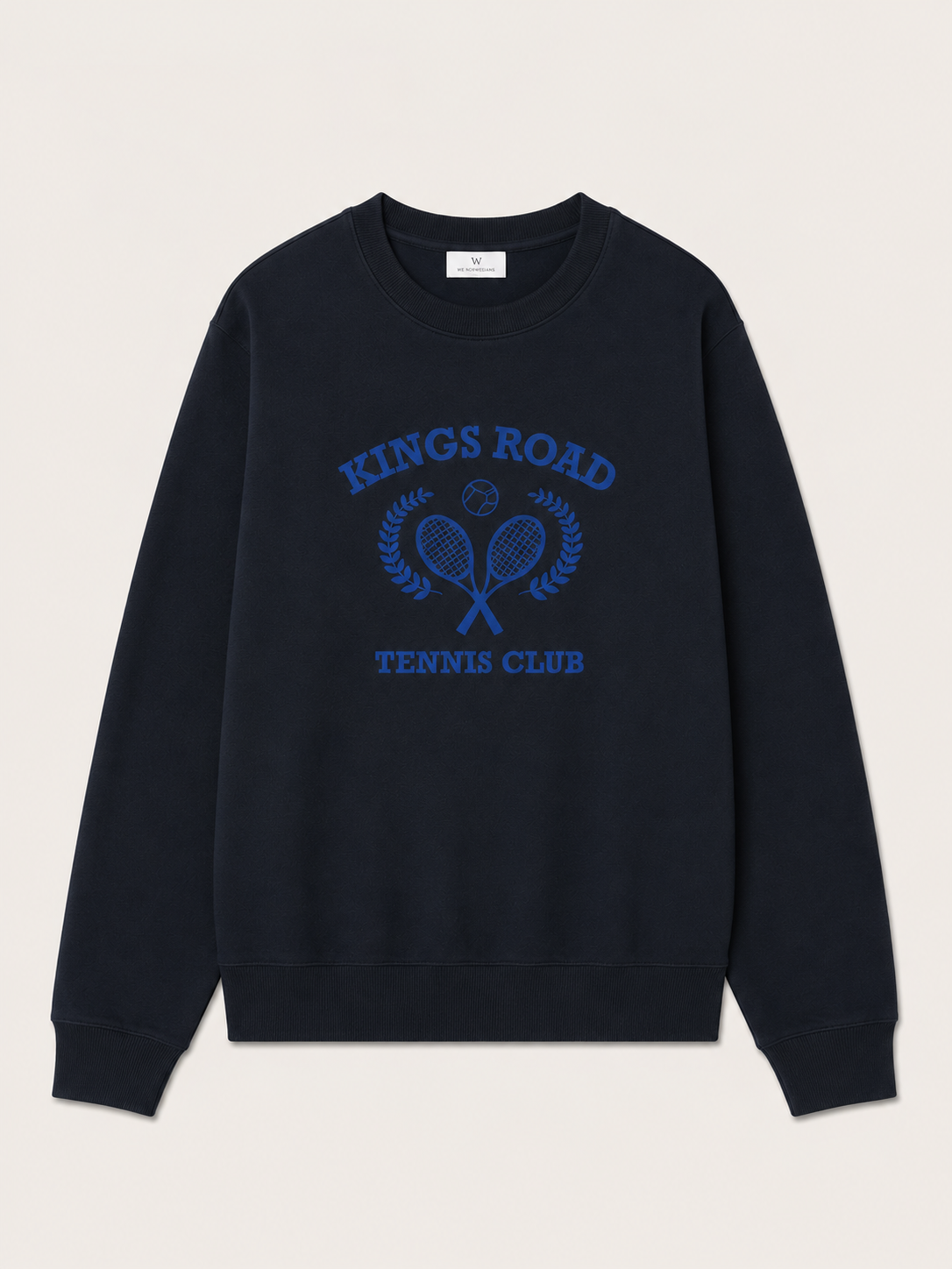The Chelsea Sweater Women by We Norwegians is a black soft cotton jersey crew neck with blue "King’s Road Tennis Club" text and front embroidery of two crossed rackets, a tennis ball, and laurel branches.