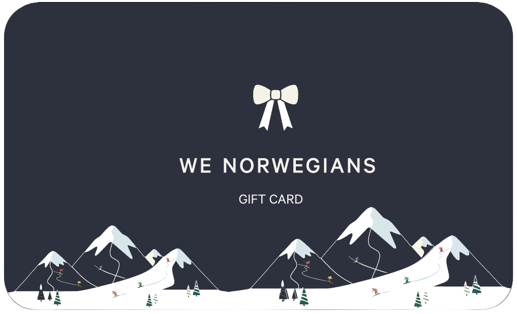 The We Norwegians Gift Card features a dark design with a white logo, bow, snow-capped mountains, skiers, and pine trees. Redeem online at wenorwegians.us or in-store at our Park City location.